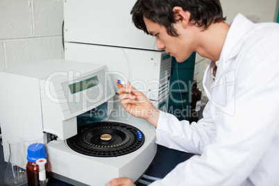 Young chemistry student using a centrifuge