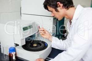 Young chemistry student using a centrifuge