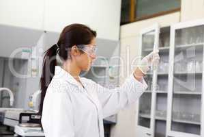 Female chemist looking at an Erlenmeyer flask