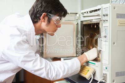 Male scientist using a laboratory chamber furnace