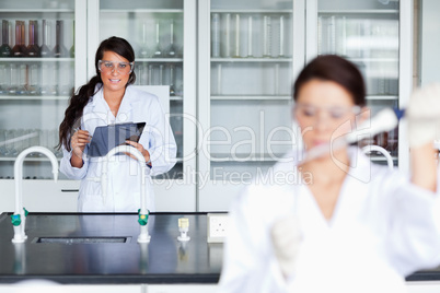 Female scientist writing on a clipboard