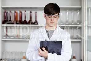 Male scientist writing on a clipboard