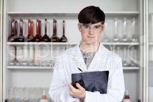 Male science student writing on a clipboard