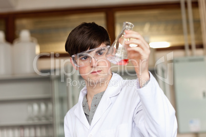 Scientist looking at a liquid in an Erlenmeyer flask