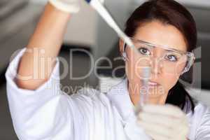 Brunette woman pouring liquid in a tube