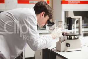 Young science student looking in a microscope