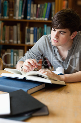 Portrait of a handsome student writing a paper