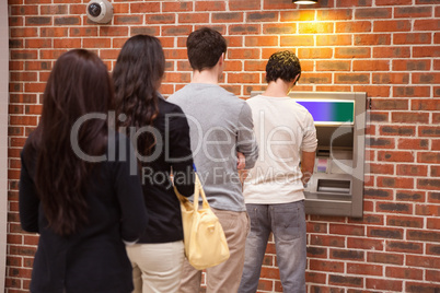 Young people queuing to withdraw cash