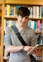 Portrait of a smiling student using a tablet computer