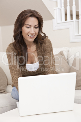 Brunette Woman Using Laptop Computer At Home on Sofa