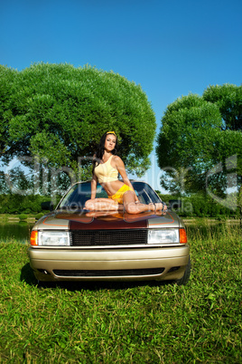 Sexy young woman sit on retro car