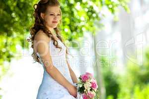 Beauty bride with flowers in sunny summer day
