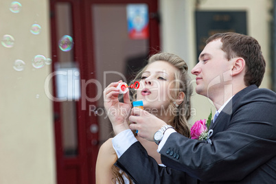just married couple blow bubbles
