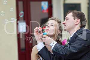 just married couple blow bubbles