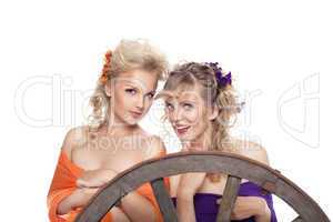 two young blond woman with flowers in hairs smile