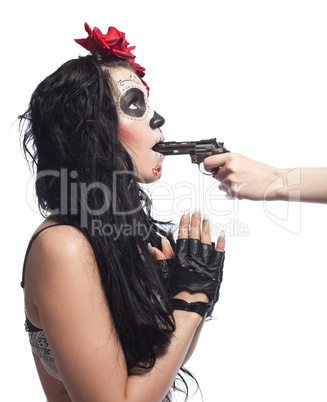 woman in day of the dead mask with gun in mouth