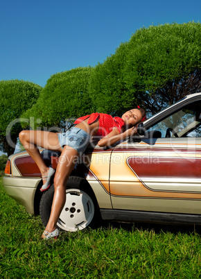 Pretty woman pin-up style lay on retro car
