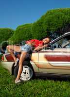Pretty woman pin-up style lay on retro car