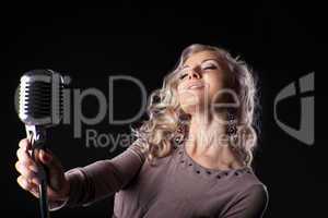 Beautiful blond woman portrait sing in microphone