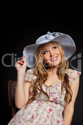 Blond pregnant woman portrait in straw hat