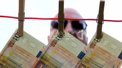 Male - watching behind money on a clothesline