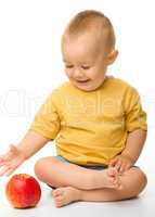Cheerful little boy with red apple