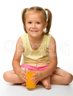 Little girl drinks orange juice