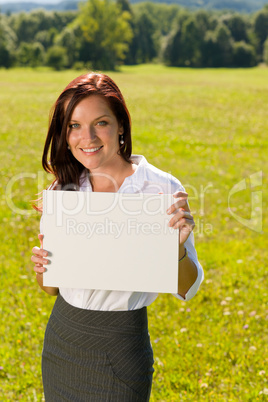 Businesswoman sunny meadow hold empty banner