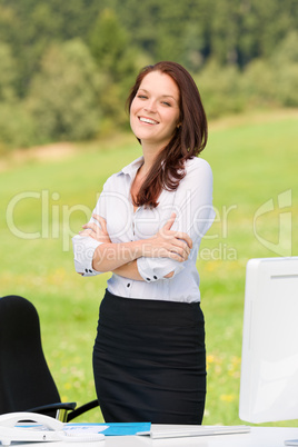 Businesswoman in sunny nature smiling crossed arms