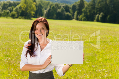 Businesswoman sunny meadow hold empty banner