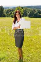 Businesswoman sunny meadow hold empty banner