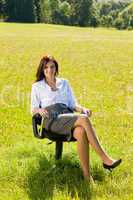 Attractive businesswoman sit armchair sunny meadow