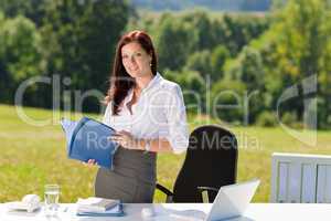 Businesswoman in sunny nature office hold folders