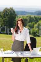Businesswoman in sunny nature office calling