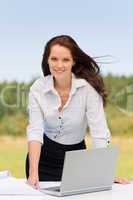 Businesswoman in sunny nature smiling with laptop