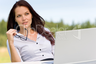 Businesswoman thoughtful sunny nature with laptop Businesswoman thoughtful sunny nature with laptop
