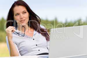 Businesswoman thoughtful sunny nature with laptop