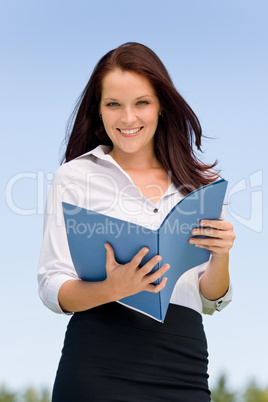 Businesswoman in sunny nature smiling hold folders Businesswoman in sunny nature smiling hold folders
