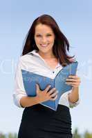 Businesswoman in sunny nature smiling hold folders