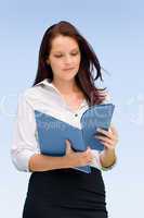 Businesswoman in sunny nature looking into folders