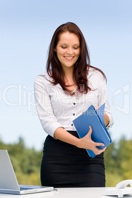 Businesswoman in sunny nature smiling hold folders