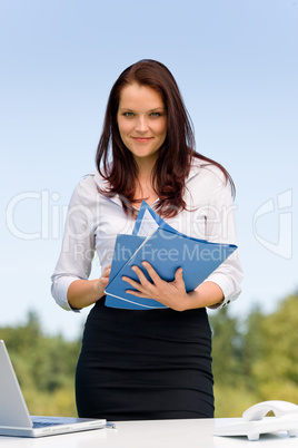 Businesswoman in sunny nature smiling hold folders