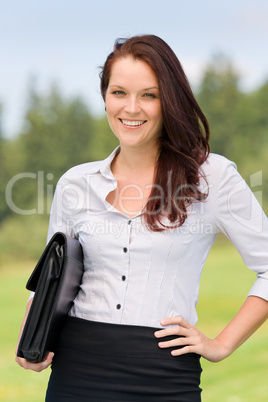 Businesswoman in sunny nature smiling briefcase