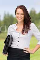 Businesswoman in sunny nature smiling briefcase