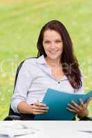 Businesswoman in nature attractive smile folder