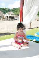 baby girl in sunglasses on the beach playing getting prepared fo