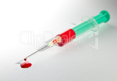 syringe laying on table filled with blood
