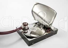 opened hard disk with stethoscope on grey background