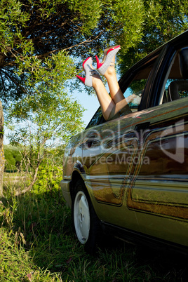 Young sexy woman lay in car  legs out