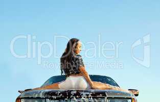sexy young girl sit on car in foam at sunset